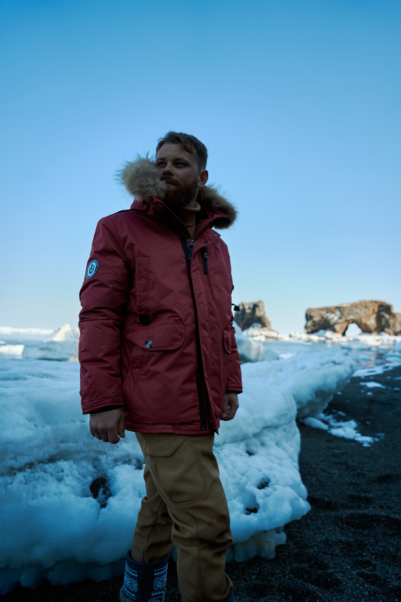 Explorer in a red bergen parka among pack ice